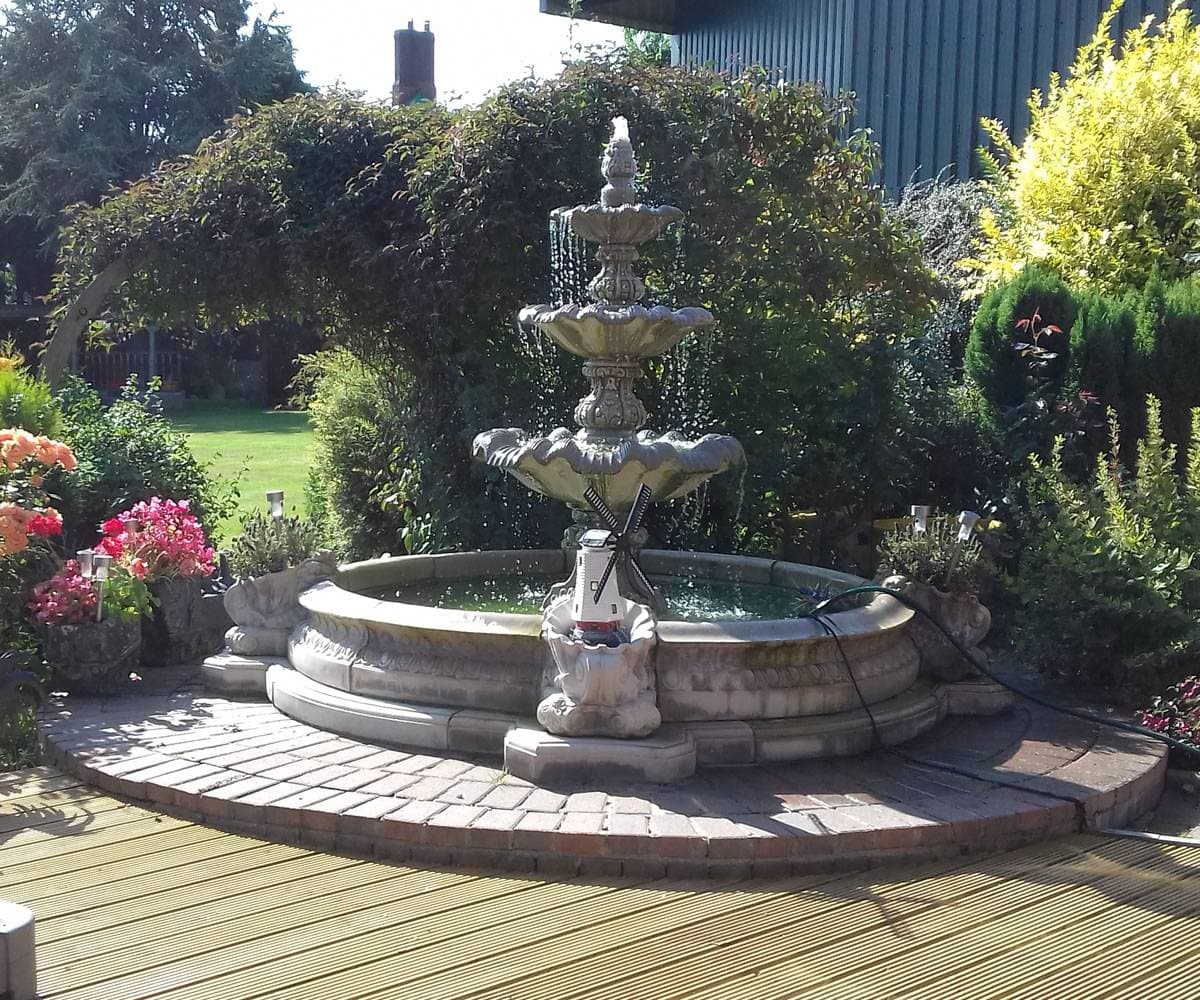 A grand tiered stone fountain in a formal garden