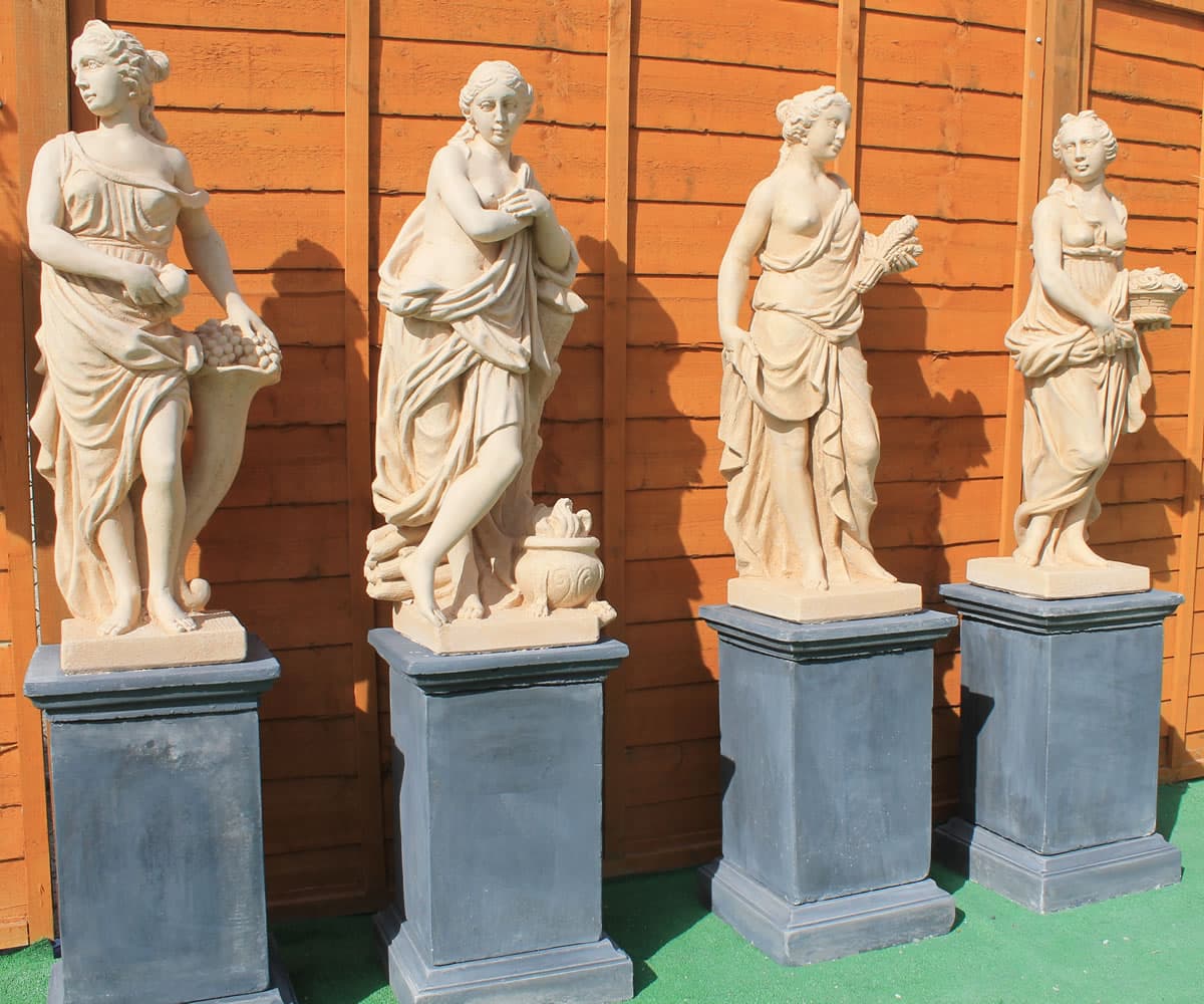 Four season statues on classic plinths showing a stone finish