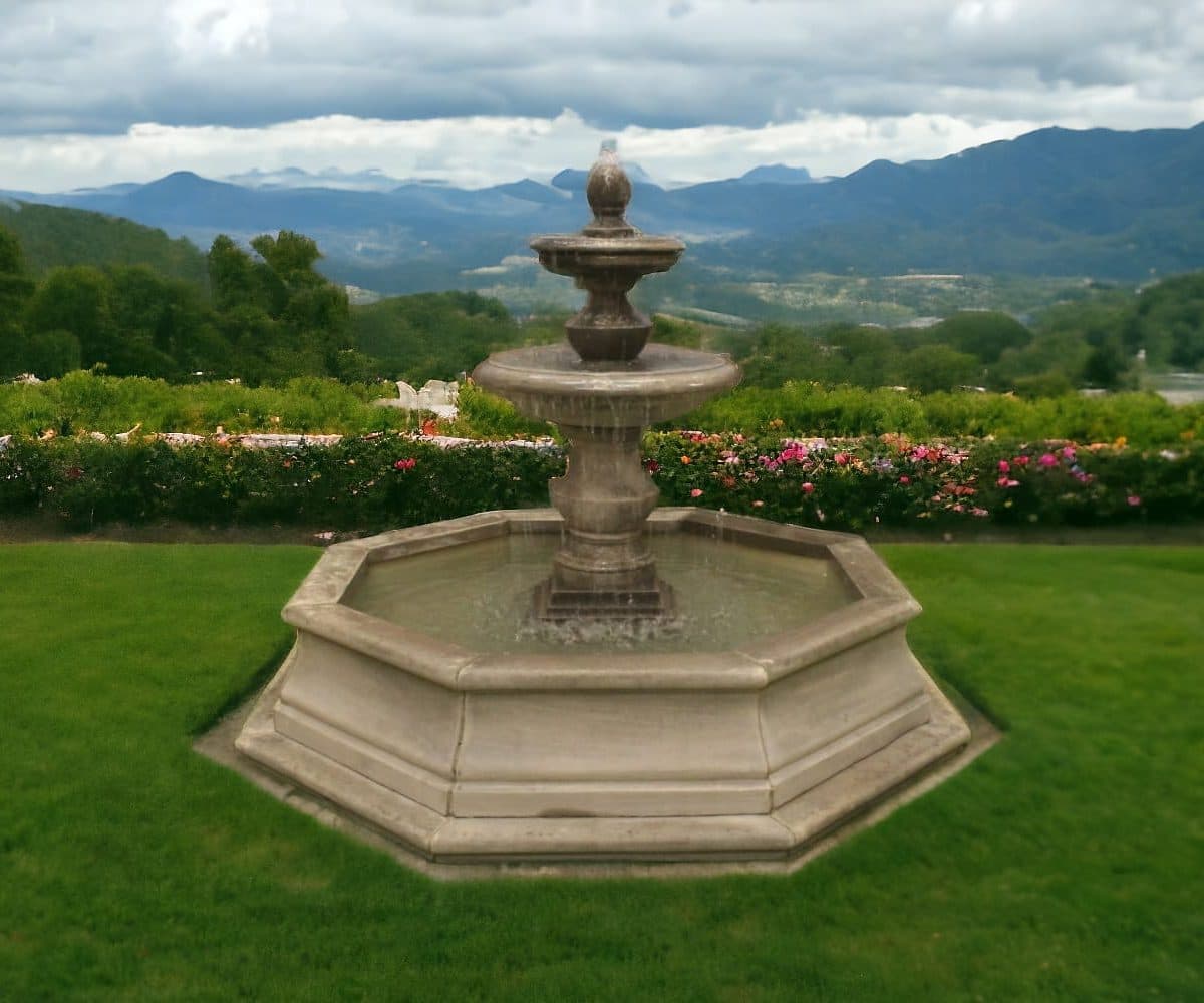 A two tiered stone ball fountain in a pool surround